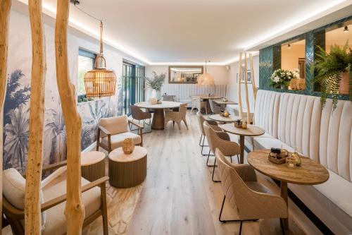 Un restaurante con mesas y sillas en una sala. en Das Oswald's Boutique Hotel, en Cuxhaven