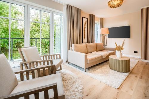 a living room with a couch and a chair at Das Oswald's Boutique Hotel in Cuxhaven