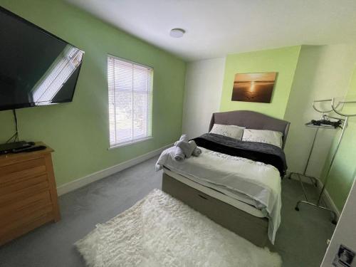a bedroom with a bed and a flat screen tv at Town House Ideal for working professionals in Stoke on Trent