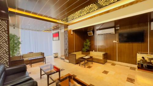 a living room with a couch and a tv and a table at Hotel The Grand Hyatt Dhaka in Dhaka