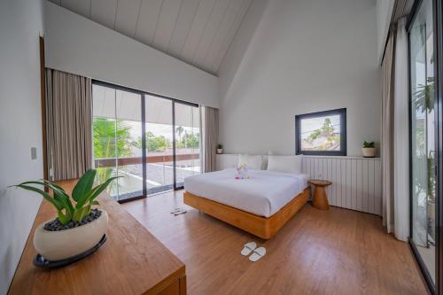 PererenanにあるVilla Shanaya Pererenanのベッドと大きな窓のある寝室