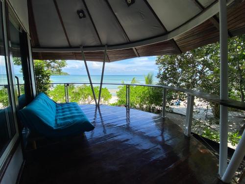 weranda z niebieską kanapą i oceanem w obiekcie Kerfuffle Bay w mieście Kaôh Rŭng (1)