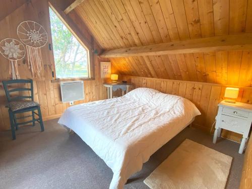 een slaapkamer met een bed en een stoel in een hut bij Maison avec jardin à TREGASTEL REF 55 in Trégastel