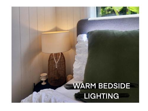 a bedroom with a bed with a lamp next to a bed at The Olive Room on Gallery Walk in Mount Tamborine