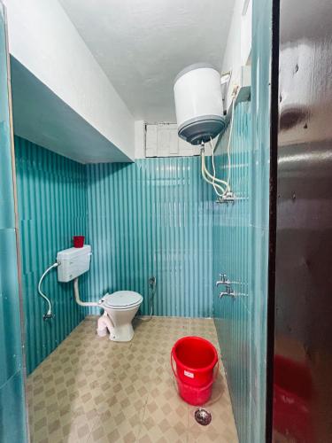 a bathroom with a toilet and a red bucket at hotel first view in Chopta