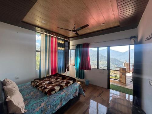Un dormitorio con una cama y una ventana grande. en hotel first view, en Chopta