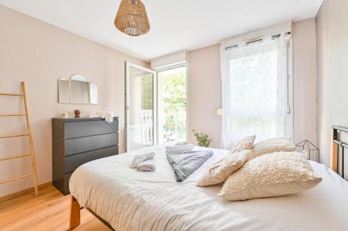 a bedroom with a bed with white sheets and pillows at Candella in Strasbourg