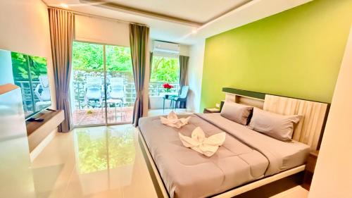 a bedroom with a large bed with two flowers on it at Abdullah Residence in Patong Beach