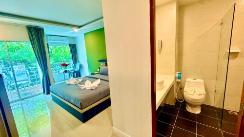 a bathroom with a bed and a toilet in a room at Abdullah Residence in Patong Beach