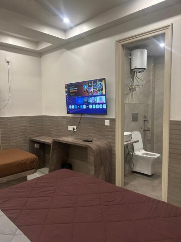 a room with a bed and a tv on the wall at Hotel Shree Guru Couple Friendly Main Bazar Paharganj New Delhi in New Delhi