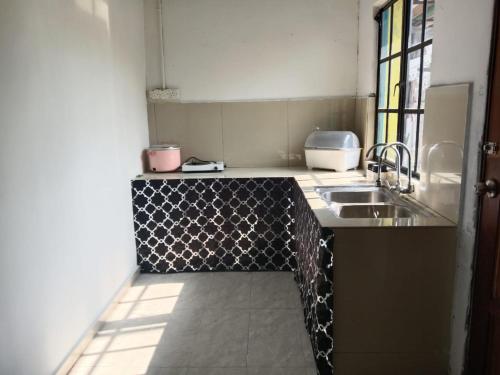 a kitchen with a sink and a counter top at Asyun Homestay 1 in Sungai Buluh