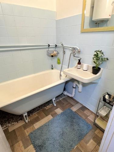 a bathroom with a tub and a sink at Sigulda's Laimas Apartment Self-Check in in Sigulda