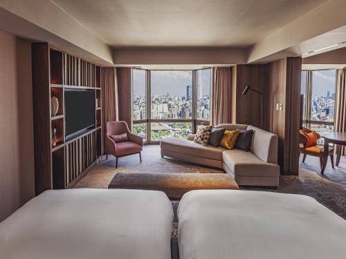 Una sala de estar con un sofá y un televisor. en Asakusa View Hotel, en Tokio