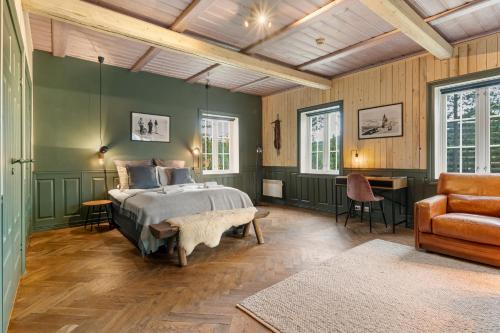 a bedroom with a bed and a table and a couch at Herangtunet Mountain Lodge in Heggenes