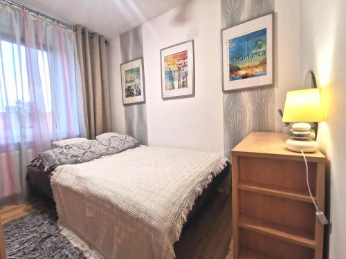 a bedroom with a bed and a lamp and a dresser at Chillout Apart pod Górą Zamkową in Wleń