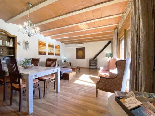 una sala da pranzo con tavolo e sedie bianchi di Can Cinto a Vilamacolum