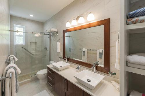 a bathroom with a sink and a shower and a mirror at Wyakha 1 Garden View in Long Bay Hills