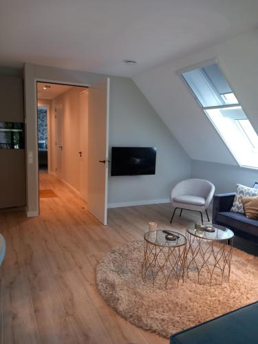 una sala de estar con un sofá y una mesa en Landgoed Erve Triesthaar, en De Lutte