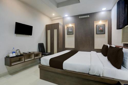 Un dormitorio con una cama grande y un televisor. en Collection O Bank More Dhanbad Formerly Hotel Sri Ganesh Ji, en Dhanbād
