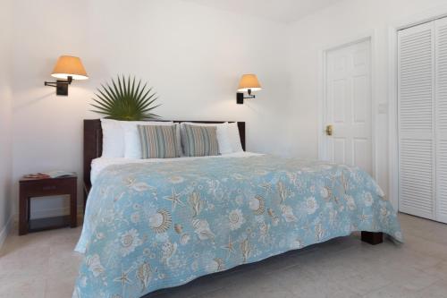 a bedroom with a bed with a blue comforter at Karana Studio 1 - K1 in Long Bay Hills