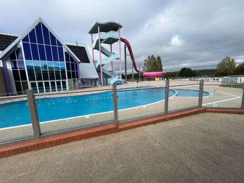 a pool with a water slide in front of a building at Meadow Banks Combe Haven in Hastings