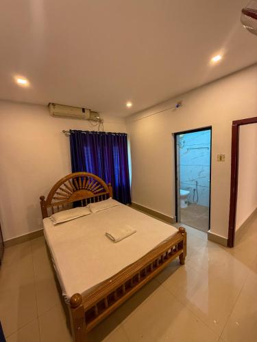 a bedroom with a bed in a room with a window at Sathya HS-2 Bedroom Family Apartments with Balcony in Guruvāyūr