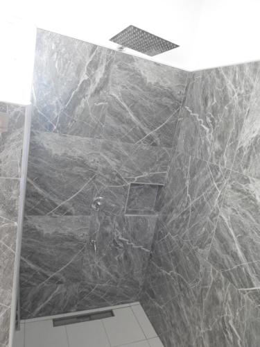 a bathroom with a large marble wall at Dom's Oase in Bolod