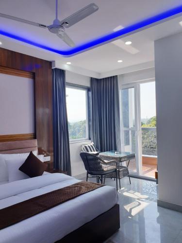 a hotel room with a bed and a table and window at Hotel Savaya Luxury Stay Near AIIMS Rishikesh in Rishīkesh