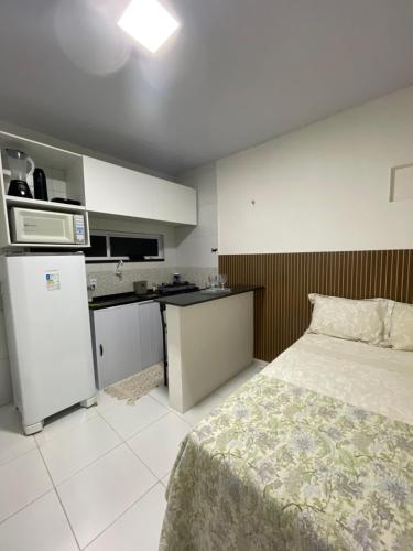 a small bedroom with a bed and a kitchen at Cantinho do amor in Fortaleza