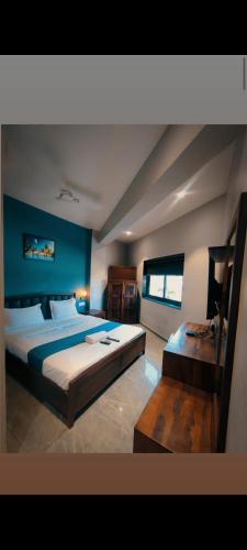 een slaapkamer met een groot bed en een tafel bij Hotel Baroda Rooms in Jāmb