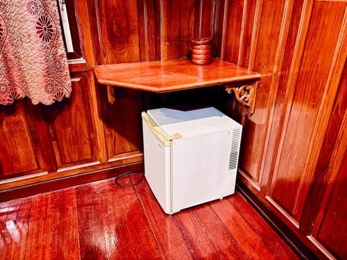 a small refrigerator in a room with a table at Sukhum Ban Songthai in Bangkok