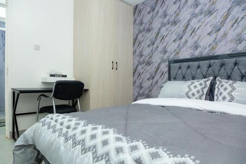 a bedroom with a large bed and a desk at Kari Cozy Homes in Nairobi