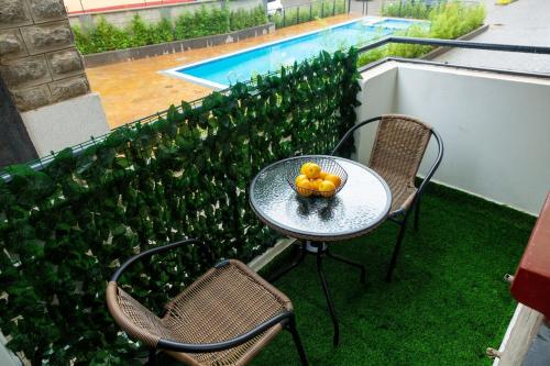 a table and chairs with a bowl of fruit on it at Kari Cozy Homes in Nairobi