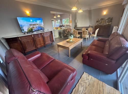a living room with two leather couches and a table at Villa Amistad in Mont-de-Marsan