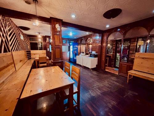 a restaurant with a wooden table and chairs in it at Sukhum Ban Songthai in Bangkok