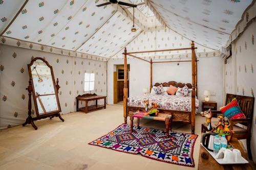 a bedroom with a canopy bed and a rug at The Mayara Fort Jaisalmer Camps in Jaisalmer