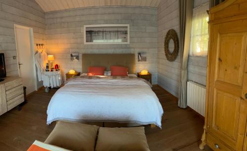 ピラ・シュル・メールにあるMaison Albatrosのベッドルーム1室(大型ベッド1台、赤い枕付)