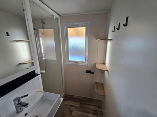 トレイユにあるGrand mobil-home familial accès direct à la mer 5 étoileの洗面台と窓のあるバスルーム