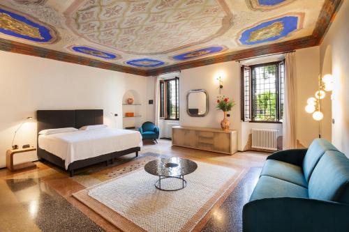 een slaapkamer met een bed, een bank en een tafel bij Apartment CastellONE with Pool in Lazise