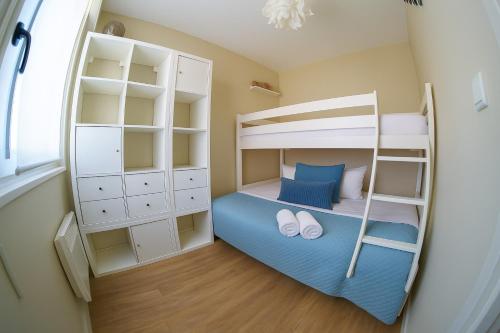 a small room with two bunk beds and a mirror at Appartement cœur de ville avec balcon - 3 personnes in Les Sables-dʼOlonne