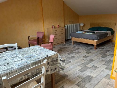 een kamer met 2 bedden en een bed en stoelen bij Les Logis du Haut-Folin in Arleuf