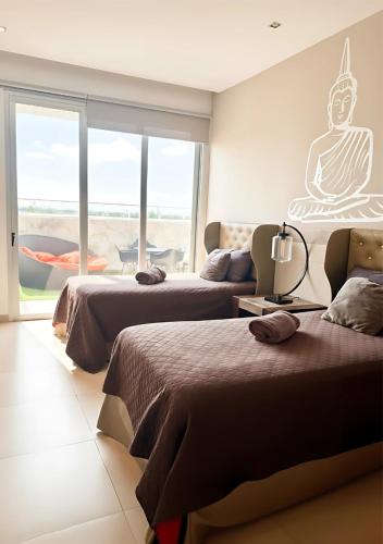 a hotel room with two beds and a couch at Casa Buddha - Pool, Jacuzzi and private terrace in Cancún