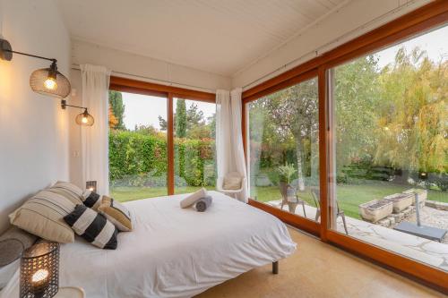 a bedroom with a bed and a large window at Villa individuelle Nernier proche lac in Nernier