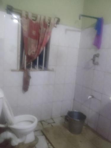 a dirty bathroom with a toilet and a shower at Ensuite in Ejigbo