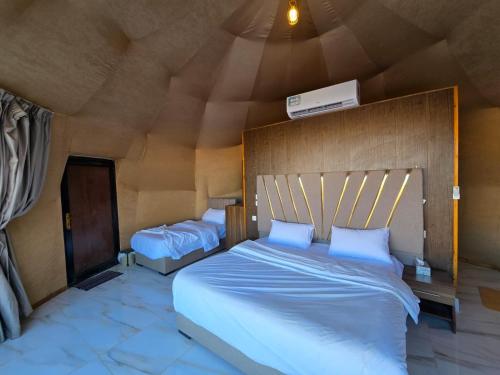 a bedroom with a large bed with a wooden headboard at Talira Luxury Camp in Wadi Rum