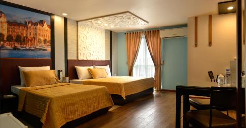 a hotel room with two beds and a desk at Eurotel Vivaldi Araneta in Manila