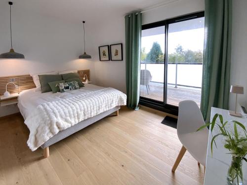 a bedroom with a bed and a large window at L'Escapade vintage in Eschau