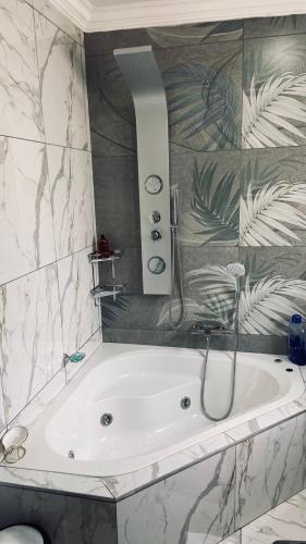 a bathroom with a bath tub with a shower at Crown Palace Guesthouse in Pretoria