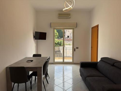 a living room with a table and a couch at Stanze Matrimoniali Nicchia della Ninfa in Castelvetrano Selinunte