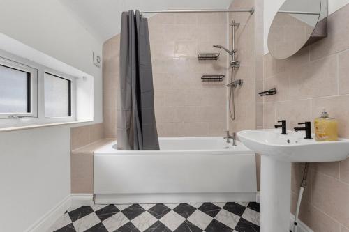 a bathroom with a tub and a sink and a shower at Convenient 2BR House with Free Street Parking in Middleton